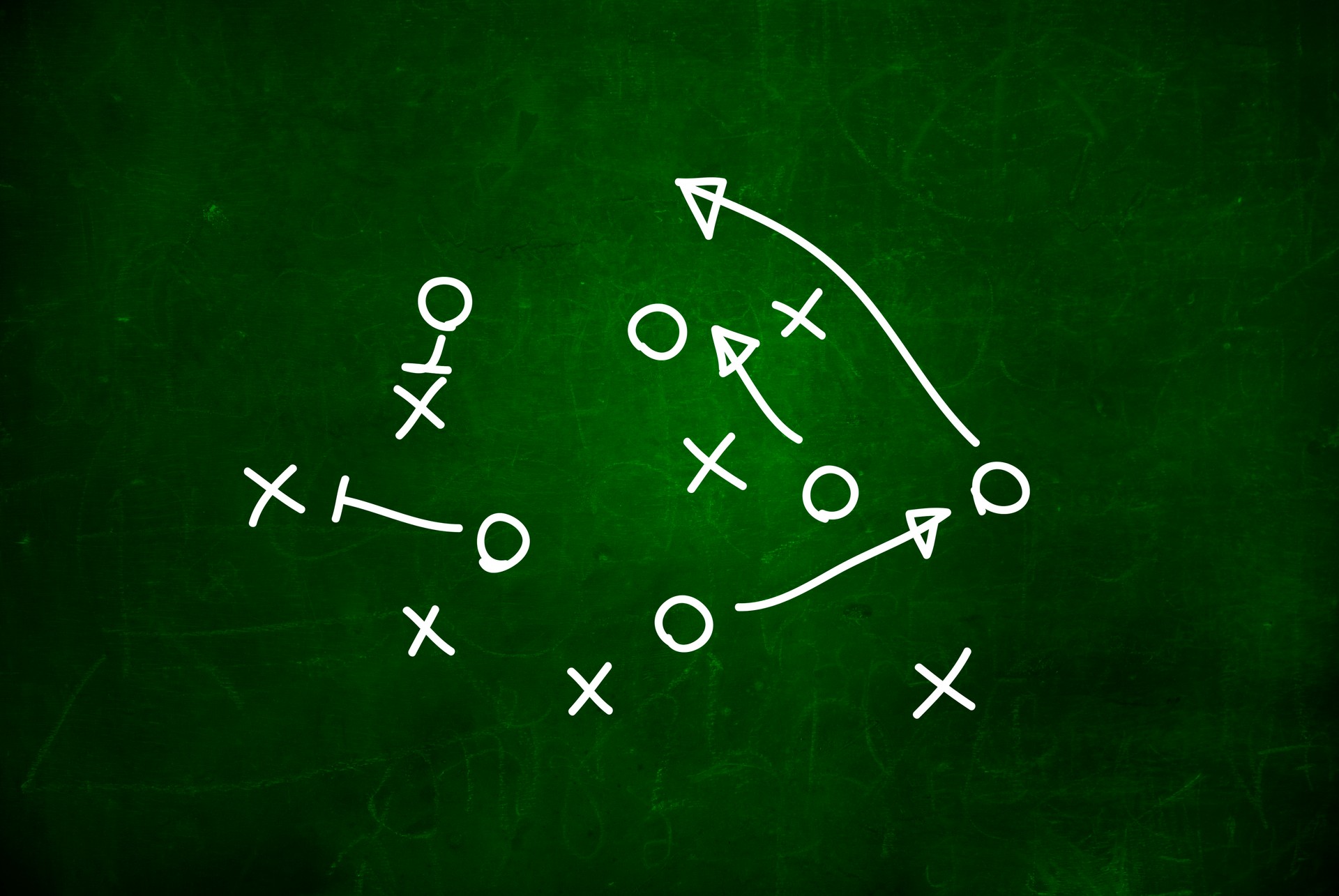 Football play strategy drawn out on a chalk board.